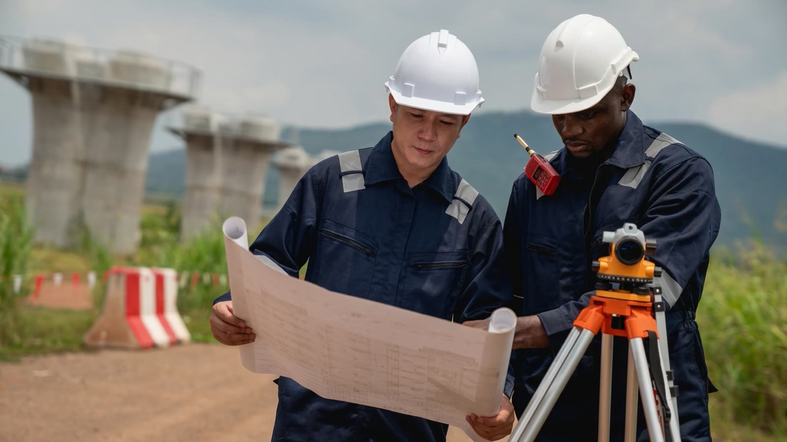 Summit Group engineers reviewing site plans with surveying equipment